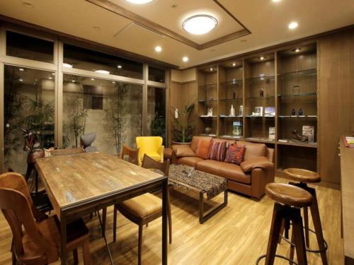 a living room with a table and a couch at Hotel Sunoak Kashiwanoha in Kashiwa