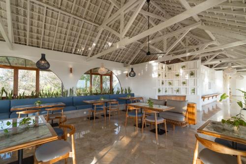 a restaurant with tables and chairs in a room at Arpana Luxury Private Pool Villas in Jimbaran