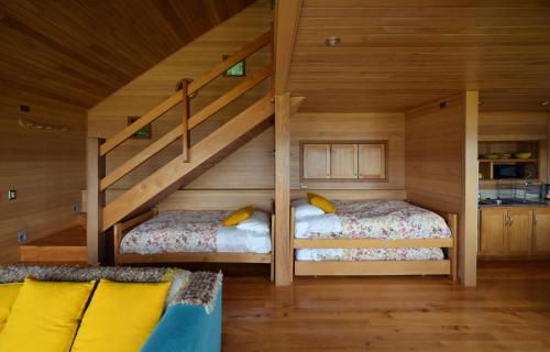 a attic room with two beds and a staircase at Cabañas Alcamar in Castro