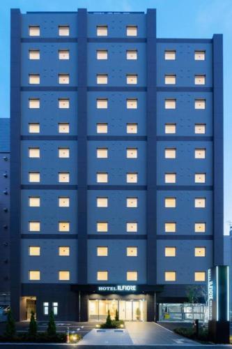 a large blue building with lights on at Hotel IL FIORE Kasai in Tokyo