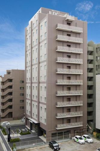 a tall building with cars parked in front of it at Hotel IL FIORE Kasai in Tokyo