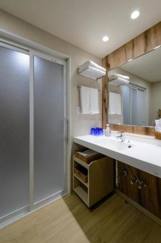 a bathroom with a shower and a white sink at Hotel IL FIORE Kasai in Tokyo