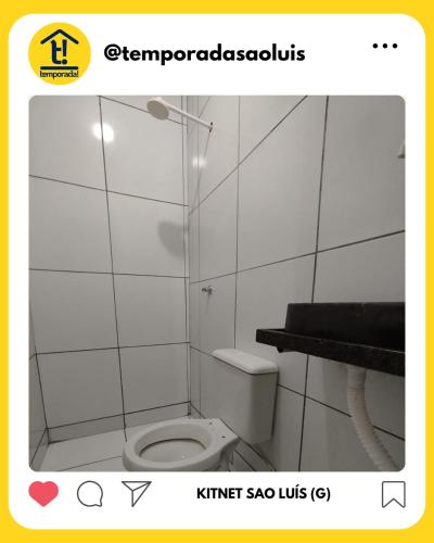 a bathroom with a toilet in a white tiled room at Kitnet São Luís - Studio G in São-José-do-Ribamar