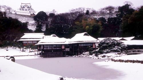 a building covered in snow with a large pond at Toyoko Inn Hikone eki Higashi guchi in Hikone