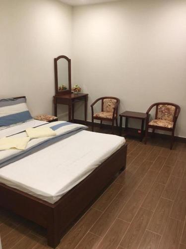 a bedroom with a bed and two chairs at Phuong Ly Ly in Ho Chi Minh City