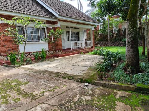 a house with a tree and a driveway at Marys Place in Entebbe
