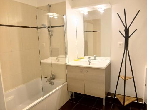 une salle de bain blanche avec un lavabo et une douche dans l'établissement Appartement Le Parc Saint Raphaël, à Saint-Raphaël