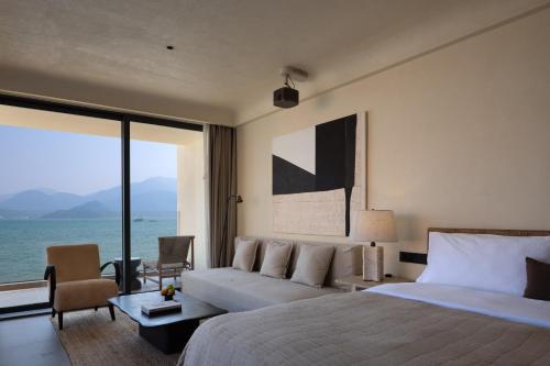 a bedroom with a bed and a view of the ocean at Mengyuan Bian Seaview Private Hot Spring Vacation Courtyard (Jiaochangwei Beach Branch) in Dapeng