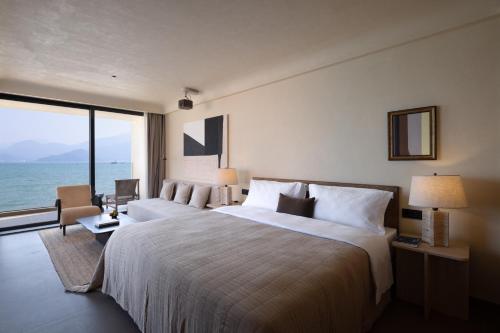 a hotel room with a large bed and a large window at Mengyuan Bian Seaview Private Hot Spring Vacation Courtyard (Jiaochangwei Beach Branch) in Dapeng