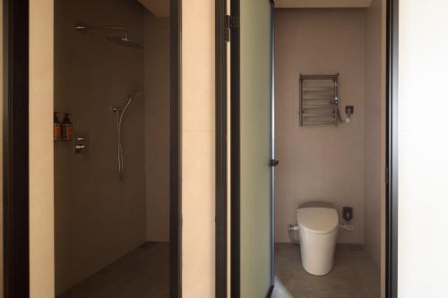 a bathroom with a shower and a toilet in it at Mengyuan Bian Seaview Private Hot Spring Vacation Courtyard (Jiaochangwei Beach Branch) in Dapeng