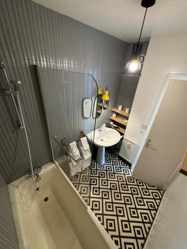Elle offre une vue sur la salle de bains pourvue d'une baignoire et d'un lavabo. dans l'établissement Studio- avec parking- proche Cathedrale, à Reims