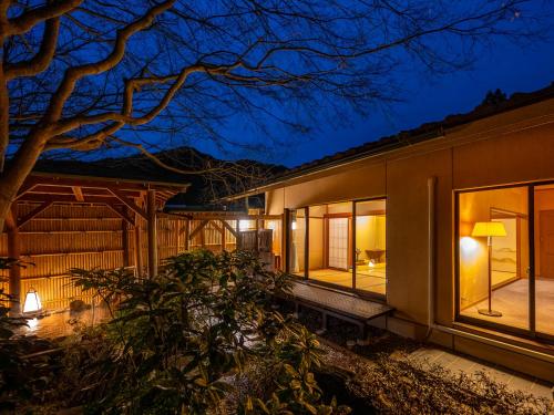a house with large windows at night at Yumoto Kanko Hotel Saikyo in Nagato