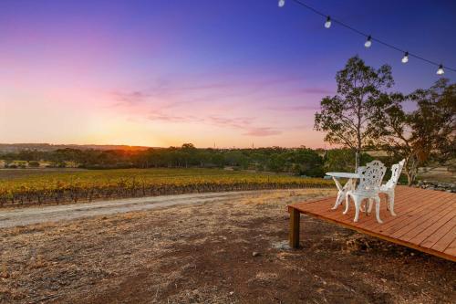 two white chairs and a table on a wooden deck at Vineyard Farmstay at Vista Fiano in Clare