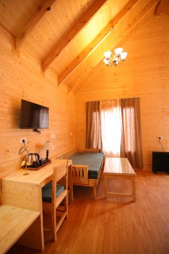 a room with a bed and a desk in a cabin at The Auli Meadows in Joshīmath