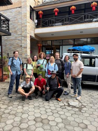 a group of people posing for a picture in front of a building at Butterfly Lodge in Pokhara