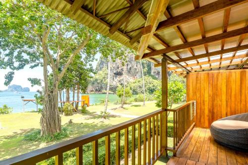 a balcony with a view of the water and a tree at Tinidee Hideaway Tonsai Beach Krabi - SHA Extra Plus in Tonsai Beach