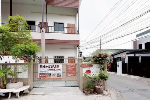 a building with a sign on the side of it at 94Home Donmuang in Bang Khen