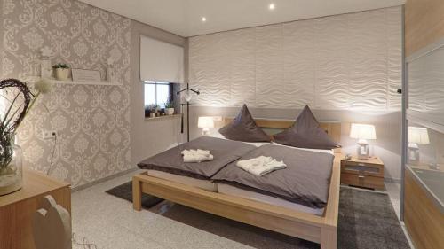 a bedroom with a bed with two pillows on it at 5-Sterne Wohlfühl-Ferienhaus Eifellust in Gönnersdorf