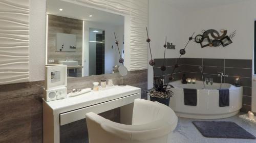 a bathroom with a toilet and a sink and a tub at 5-Sterne Wohlfühl-Ferienhaus Eifellust in Gönnersdorf