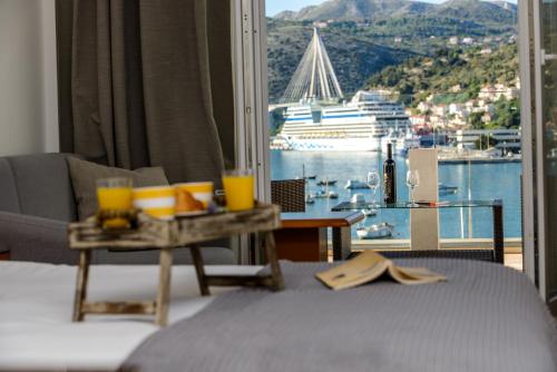 a hotel room with a bed with a view of a cruise ship at Adriatic Deluxe Apartments in Dubrovnik