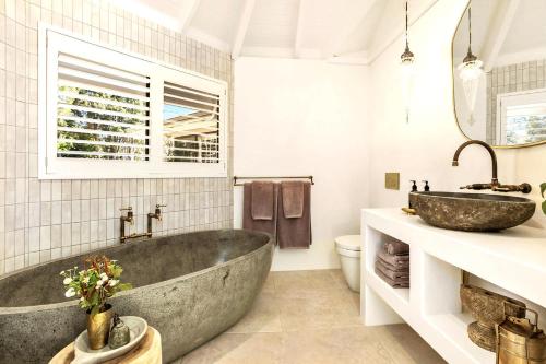 a bathroom with a large tub and a sink at Meadows House & Events in Bangalow
