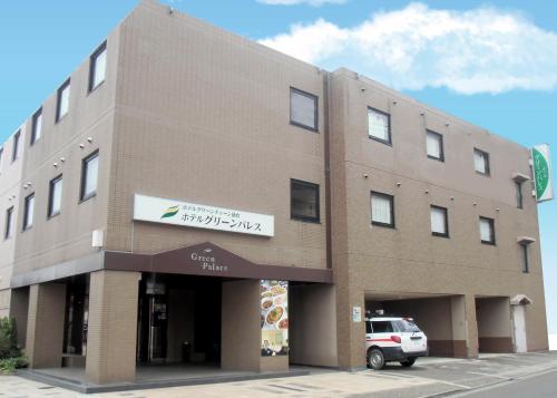 a building with a car parked in front of it at Hotel Green Palace in Sendai