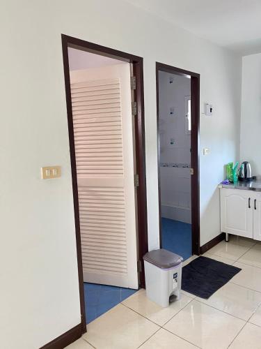 a bathroom with two doors and a trashcan in a room at TONY Central Stay in Phuket