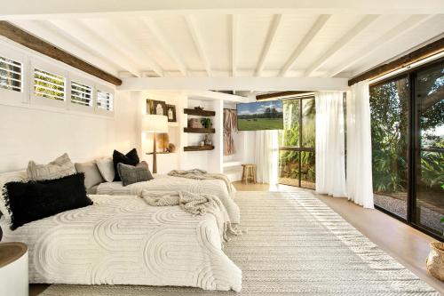 two beds in a living room with a large window at Meadows Estate in Bangalow