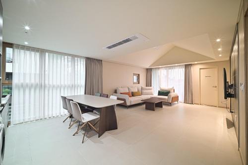 a living room with a table and a couch at Masion Sanbang Jeju in Seogwipo