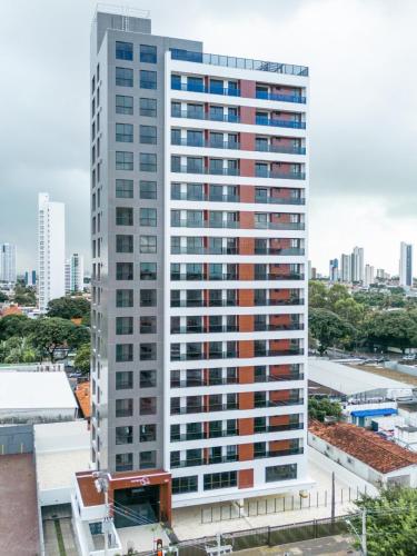 a tall building with many windows in a city at Compact Time apto 406 Lindo Flat in João Pessoa