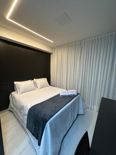 a bedroom with a large bed with white sheets at Compact Time apto 406 Lindo Flat in João Pessoa