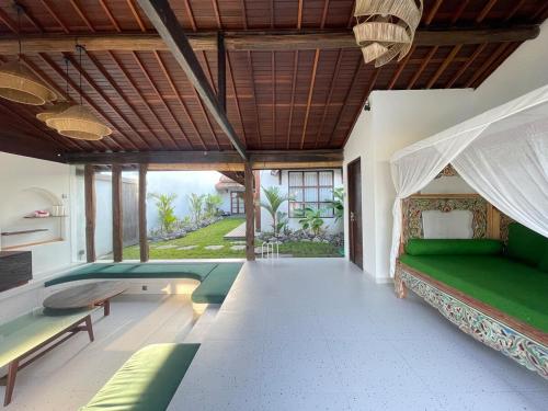 Tanah Lot Dreams Complex Villas By GUMA Hospitality في تاناه لوت: غرفة مع حمام سباحة مع سرير وأريكة