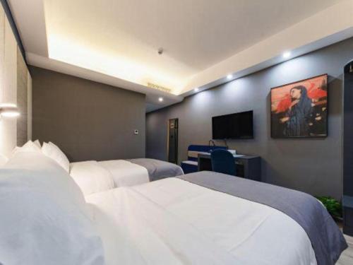 a hotel room with two beds and a television at LANO Hotel Shandong Qingdao Jimo District Baolong Square in Qingdao