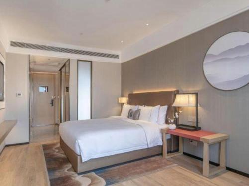 a bedroom with a large bed and a mirror at E-Cheng Hotel Shenyang North Railway Station in Shenyang