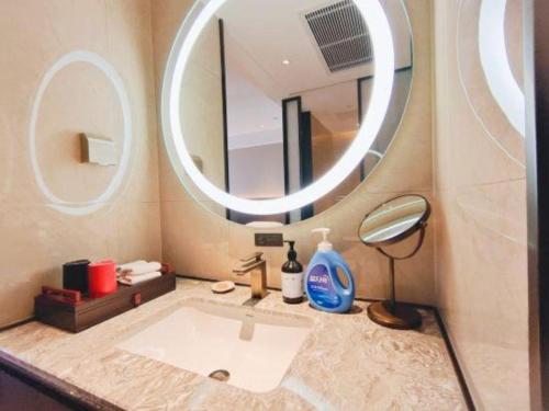 a bathroom with a sink and a large mirror at E-Cheng Hotel Shenyang North Railway Station in Shenyang