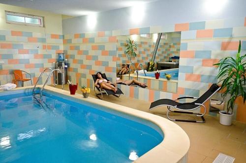 a swimming pool with people sitting in chairs in a bathroom at Castle Residence Praha in Prague
