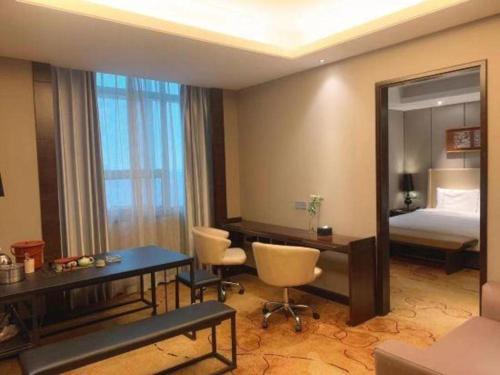 a hotel room with a desk and a bed and a mirror at E-Cheng Hotel Shenyang North Railway Station in Shenyang