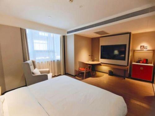 a hotel room with a bed and a flat screen tv at E-Cheng Hotel Shenyang North Railway Station in Shenyang