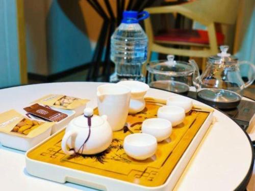 a table with a tray with cups and a bottle of water at E-Cheng Hotel Shenyang North Railway Station in Shenyang