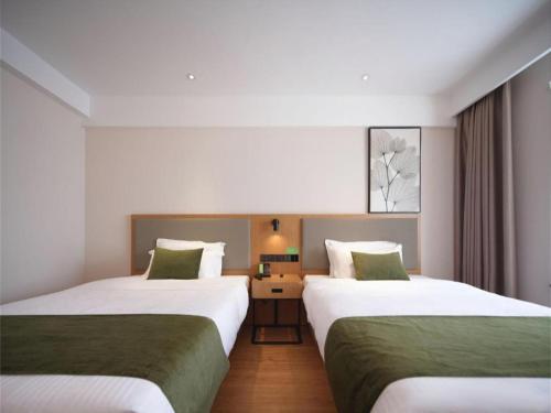 Ein Bett oder Betten in einem Zimmer der Unterkunft GreenTree Inn Luoyang Railway Station Wangfujing Wangcheng Park