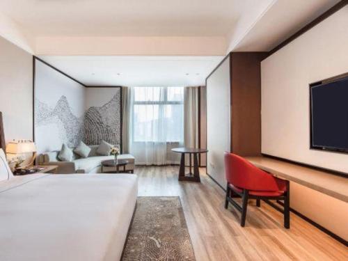 una camera d'albergo con un letto e una TV a schermo piatto di GreenTree Eastern Hotel Nanning Wuxiang Hangyang City a Nanning