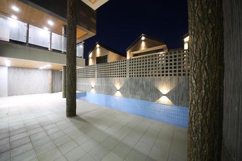 a building with a swimming pool at night at Masion Sanbang Jeju in Seogwipo