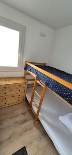 une chambre avec deux lits superposés et une fenêtre dans l'établissement Studio 6 pers, vue mer, parking, wifi, ponton, au Cap d'Agde