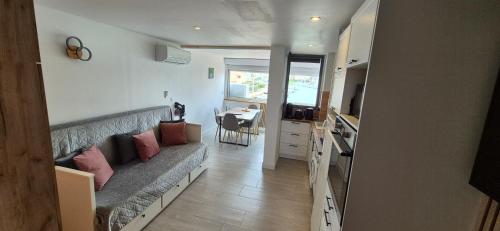 un salon avec un canapé et une cuisine avec une table dans l'établissement Studio 6 pers, vue mer, parking, wifi, ponton, au Cap d'Agde