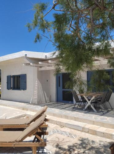 a patio with two chairs and a house at House On The Wave in Marathokampos