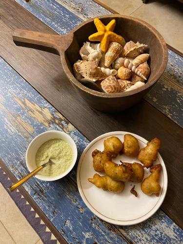 a table with a bowl of dip and a plate of food at SeaEsta Beach House in Pāngāla