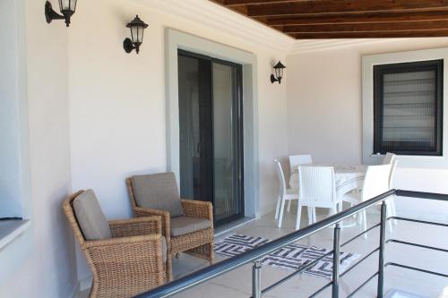 un balcone con sedie e un tavolo su un balcone di Bozcada Aden Vineyard a Bozcaada