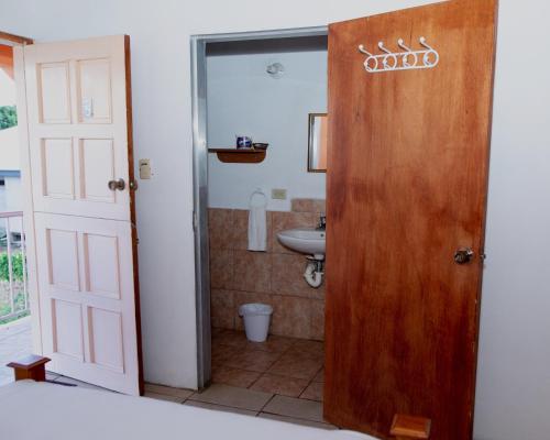 a bathroom with a wooden door and a sink at Lesville Tobago in Canaan