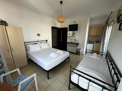 a bedroom with two beds and a kitchen at Apartments Villa Effie in Paralia Katerinis