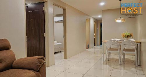 a living room with a couch and a table and chairs at Triima Inn Dayang Bay by Perfect Host in Kuah